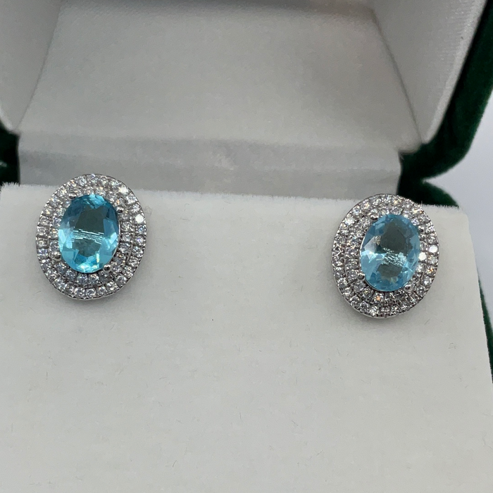 Sterling Silver Oval Simulated Blue Topaz with CZ Border Earrings